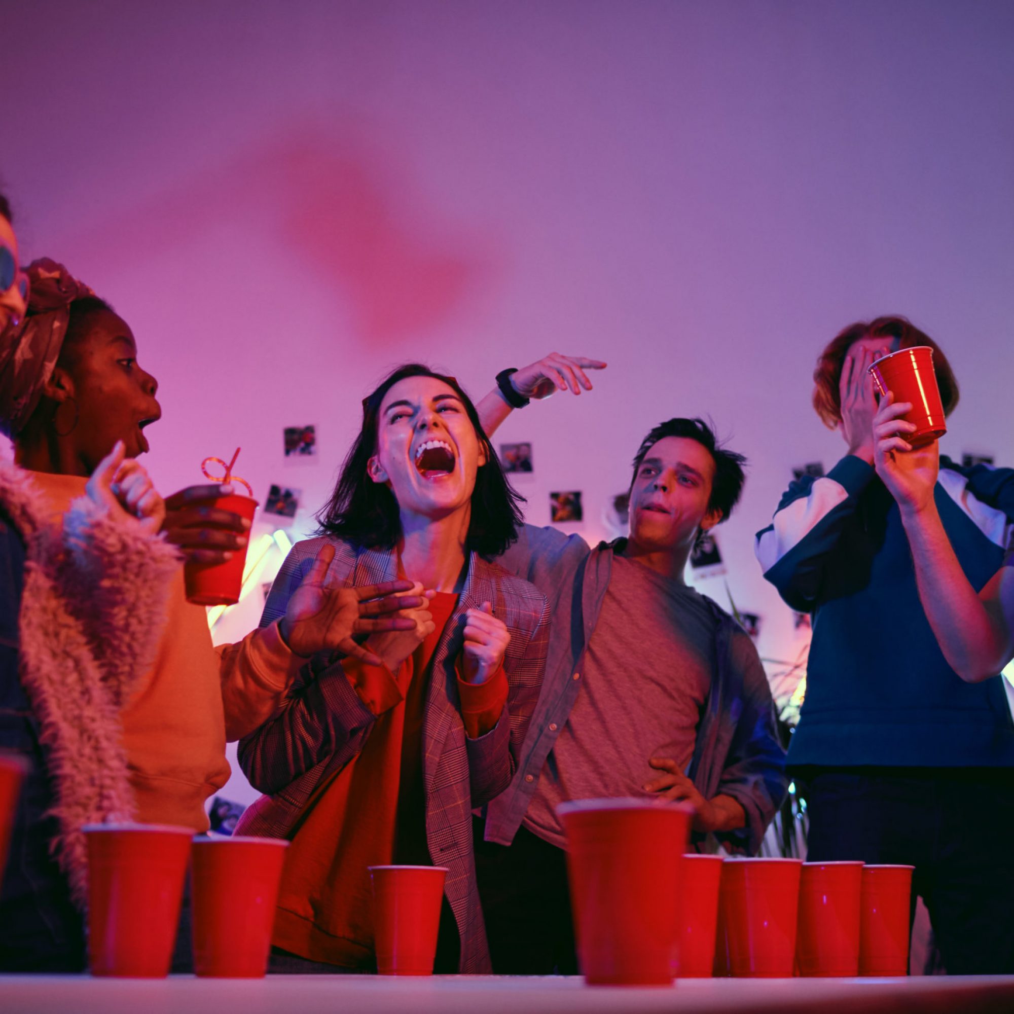 Young,Woman,Laughing,While,Playing,In,Beer,Pong,Game,Together
