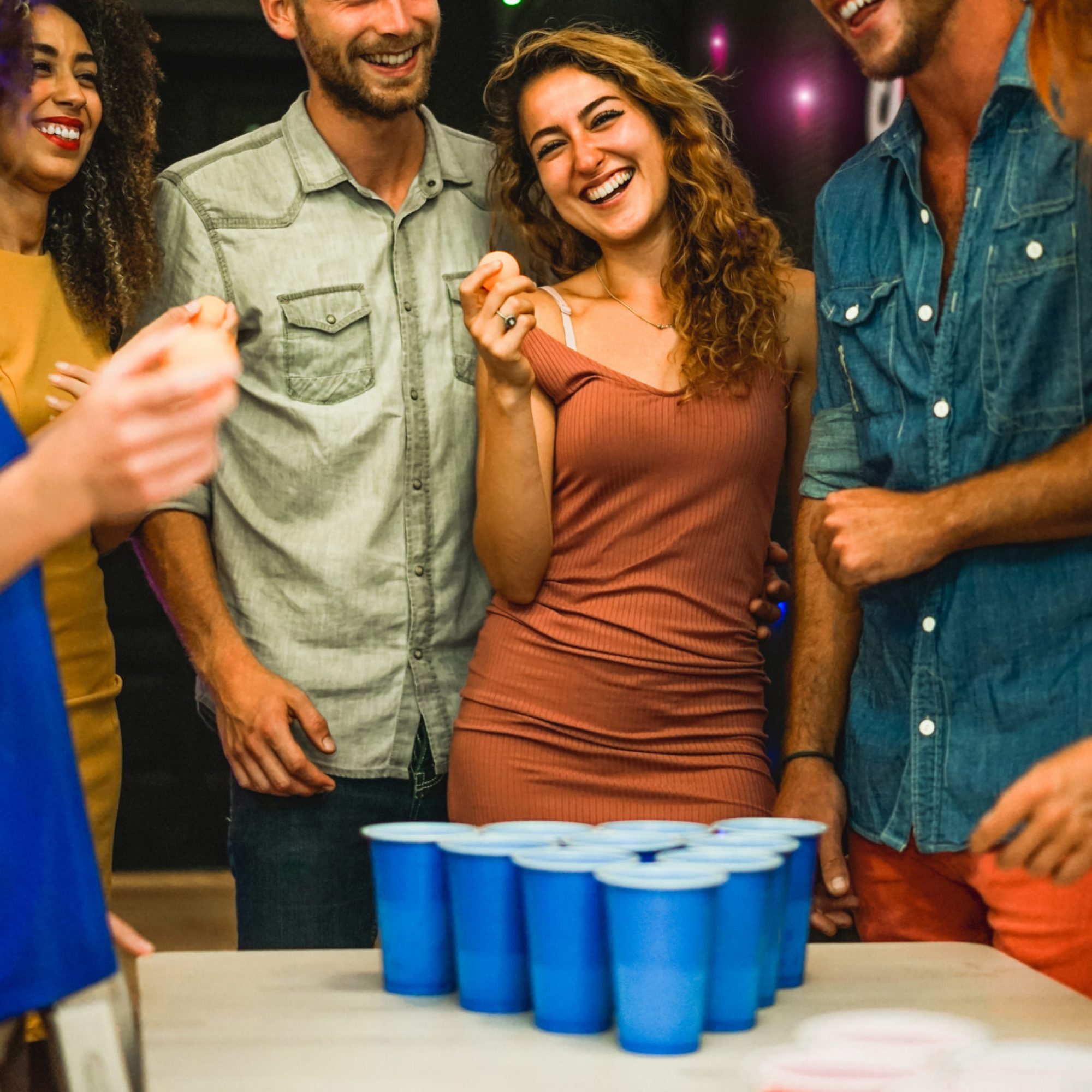Happy,Friends,Playing,Beer,Pong,In,Hostel,Bar,-,Young